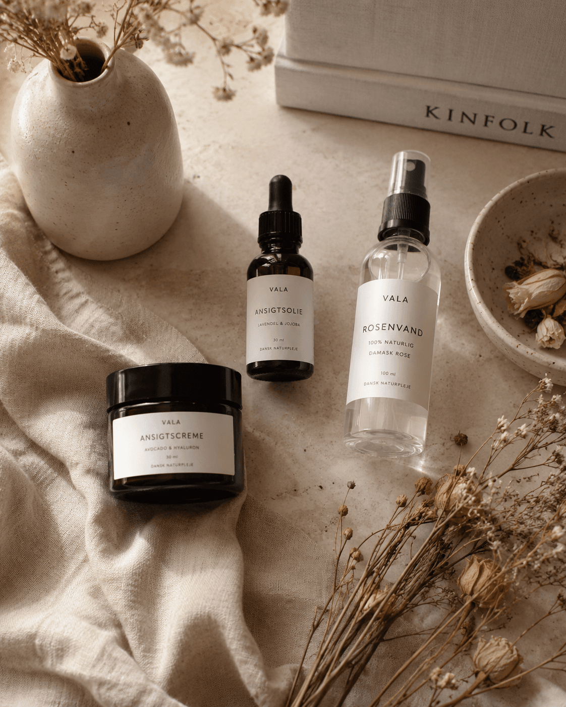 Dansk vinterhudpleje flat lay fugtighedscreme ansigtsolie rosenolie tørrede blomster — hygge Elixiria