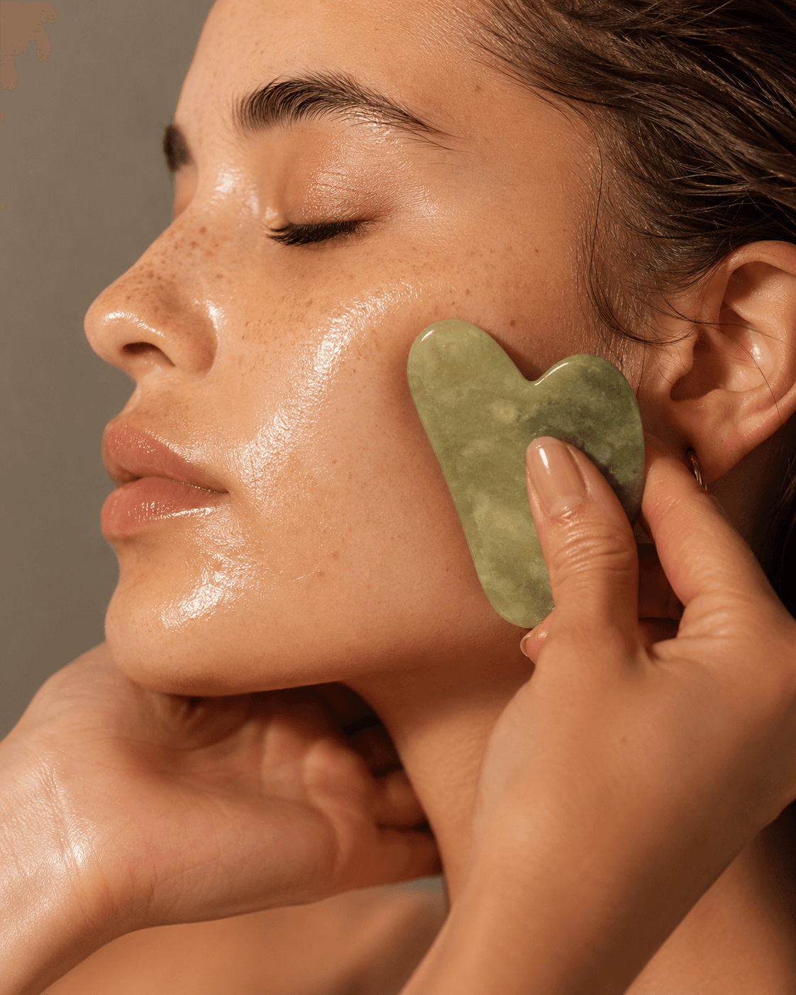 Technique de massage facial gua sha sur la pommette avec huile